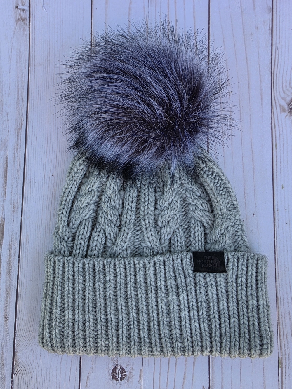 The North Face Women's Cable Knit Pom Beanie in Light Gray with Faux Fur Pom